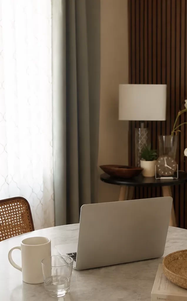 Desk with a laptop and coffee mug for virtual therapy sessions